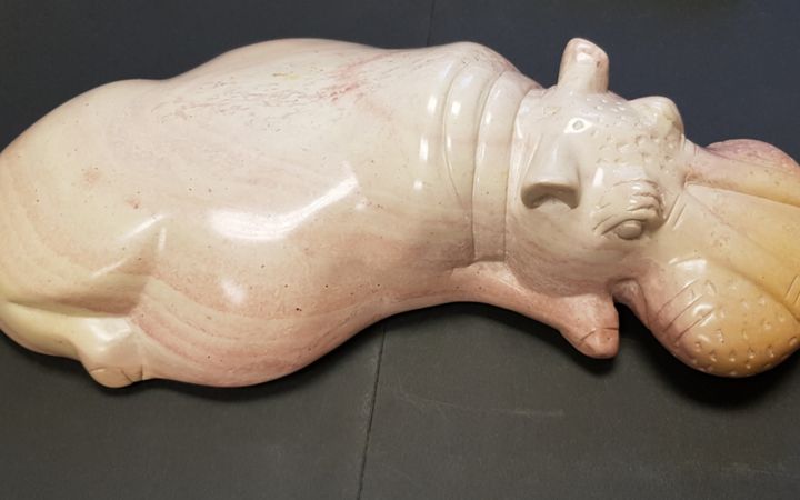 Escultura de hipopótamo sedente tallada en mármol rosa,