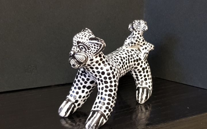 Figura de barro pintado en blanco y negro que representa un tigre, típico de México